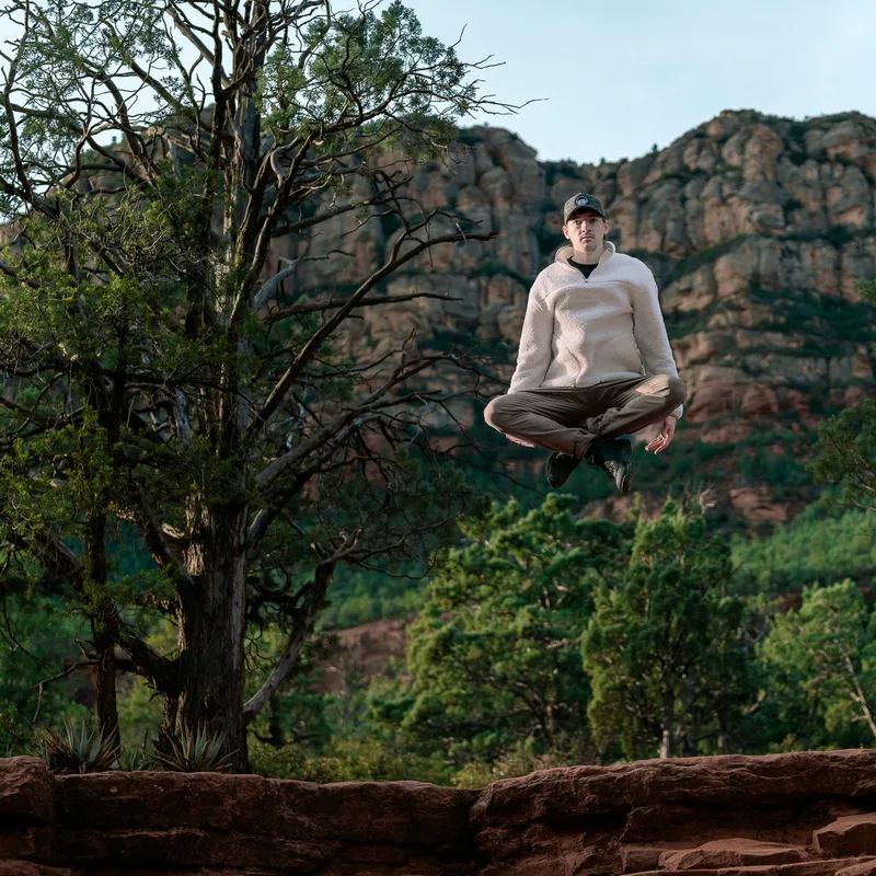 Austin jumping in front of a mountain